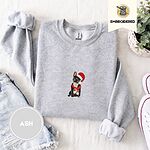 Ash crewneck sweatshirt folded with denim shorts, white sneakers and a potted plant, embroidered with a black French bulldog with a cream chest in a Santa hat and a red scarf with white zigzag stripes
