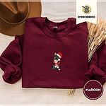 Maroon crewneck sweatshirt with a brown felt hat and dried bunny tail grass, embroidered with a black French bulldog with a cream chest in a Santa hat and a red scarf with white zigzag stripes