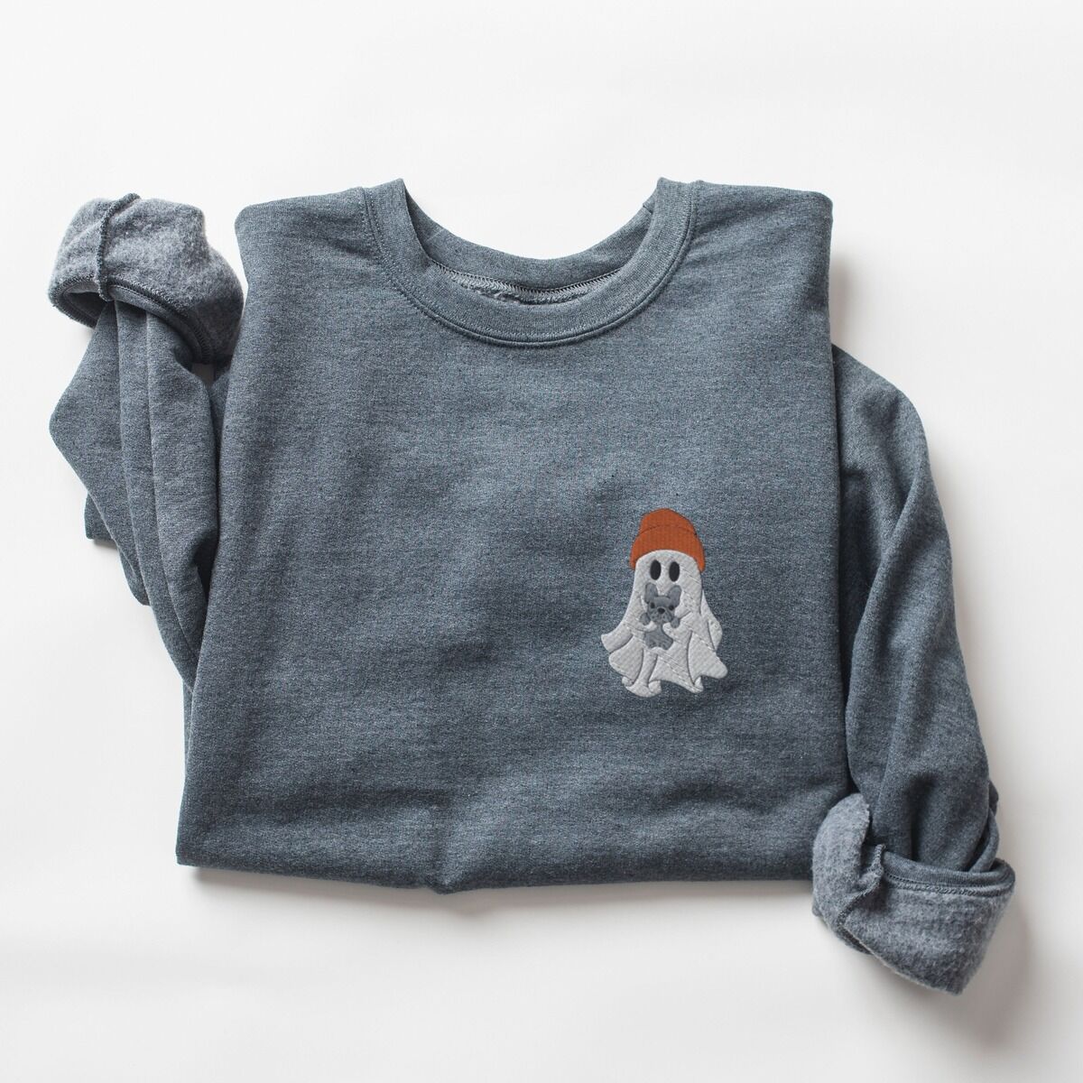 Frenchie Ghost Sweatshirt – Dark Heather Dark Heather crewneck sweatshirt laid flat with rolled sleeves, embroidered with a little ghost in a rust knit beanie hugging a grey French bulldog on the left chest