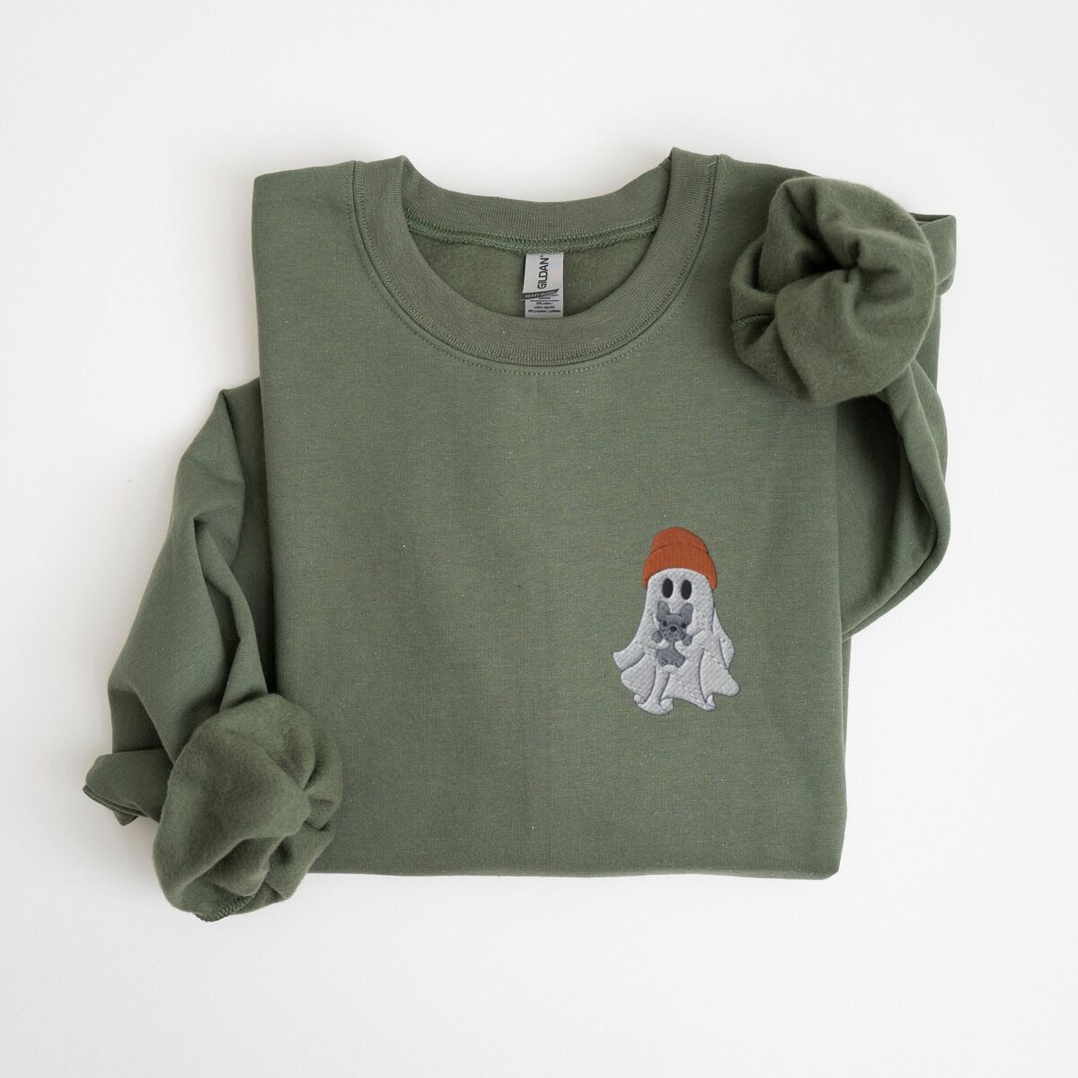 Frenchie Ghost Sweatshirt – Military Green Military Green crewneck sweatshirt laid flat on a white background, embroidered with a little ghost in a rust knit beanie hugging a grey French bulldog on the left chest