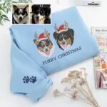 Light blue Furry Christmas sweatshirt with two embroidered dog portraits in antlers and Santa hats, next to the owner's dog photos