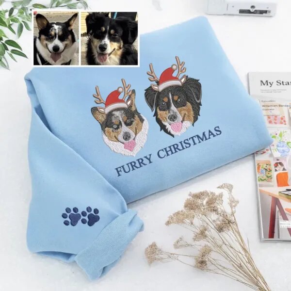 Light blue Furry Christmas sweatshirt with two embroidered dog portraits in antlers and Santa hats, next to the owner's dog photos
