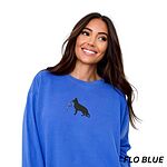 Woman in an oversized Flo Blue crewneck sweatshirt embroidered with a black German shepherd silhouette carrying a string of colored Christmas lights