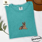 Seafoam Comfort Colors T-shirt embroidered with a black and tan German shepherd lying down with its ears up and its paws forward