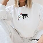 Woman in a White crewneck sweatshirt embroidered with a black German shorthaired pointer in a Santa hat holding Christmas lights