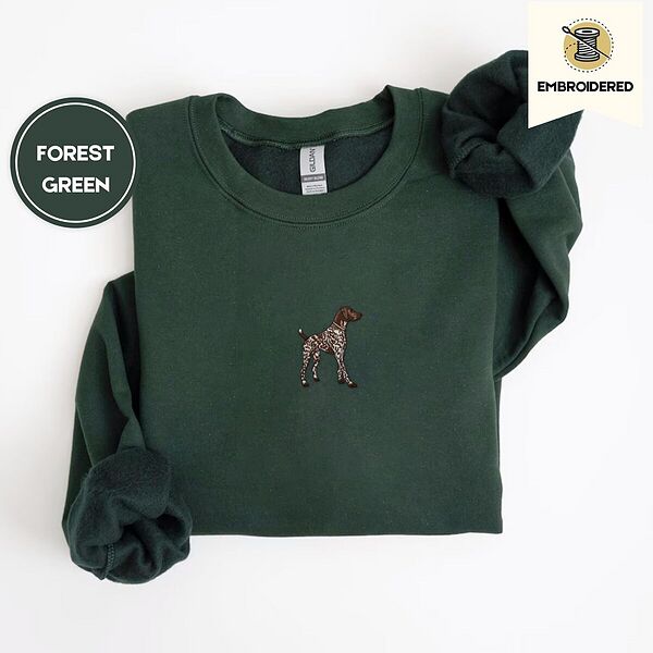 Forest Green crewneck sweatshirt folded on a white background, embroidered with a standing liver and white German shorthaired pointer in a tan collar