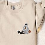 Sand crewneck sweatshirt laid flat with a rolled cuff, embroidered with a ghost sipping iced coffee with a black pit bull in a play bow on the left chest