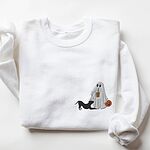 White crewneck sweatshirt laid flat on a white background, embroidered with a ghost sipping iced coffee with a black pit bull in a play bow on the left chest