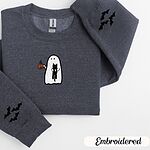 Dark Heather crewneck sweatshirt folded on a white background, embroidered with a white ghost hugging a black cat and holding a steaming jack-o'-lantern coffee mug, with small bats on the sleeves