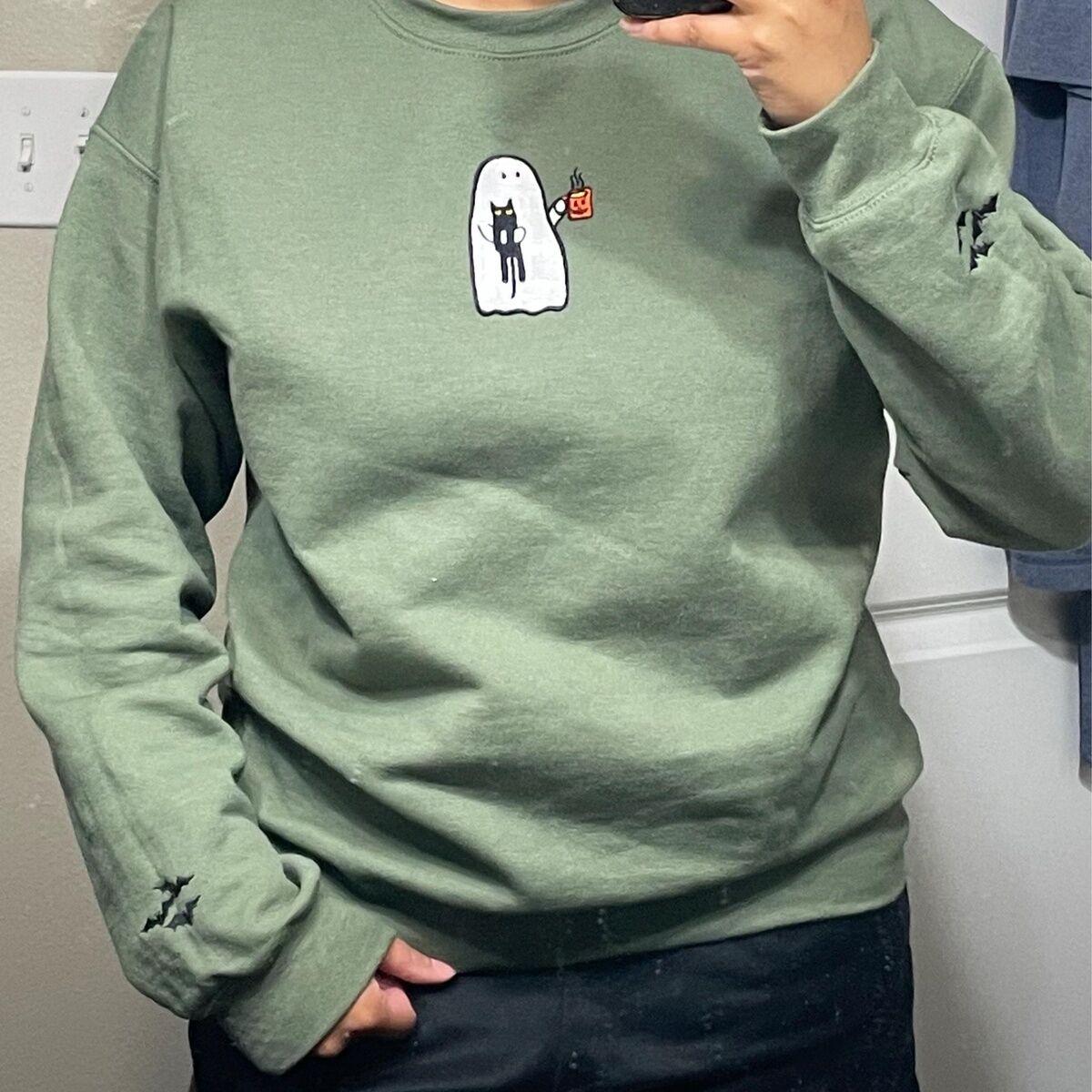 Ghost Drinking Coffee Sweatshirt – Customer Photo 2 Customer photo: mirror selfie in a Military Green ghost drinking coffee sweatshirt, with the embroidered ghost on the chest and bats on both sleeves