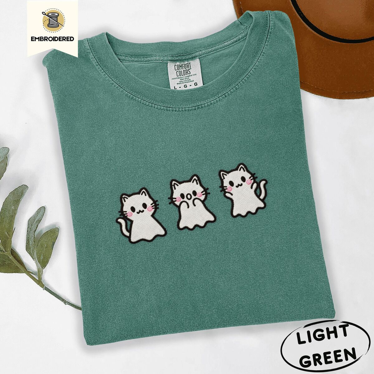Ghost Kitten Shirt – Light Green Light Green Comfort Colors T-shirt embroidered with three white ghost kittens with pink cheeks and black outlines