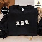 Black crewneck sweatshirt with a brown felt hat and dried bunny tail grass, embroidered with three white ghost kittens with pink cheeks and black outlines