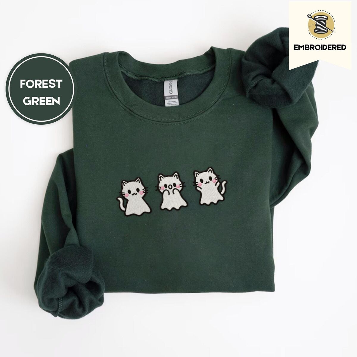 Ghost Kitten Sweatshirt – Forest Green Forest Green crewneck sweatshirt folded on a white background, embroidered with three white ghost kittens with pink cheeks and black outlines