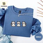 Indigo Blue crewneck sweatshirt folded with light jeans and dried twigs, embroidered with three white ghost kittens with pink cheeks and black outlines