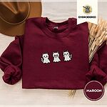 Maroon crewneck sweatshirt with a brown felt hat and dried bunny tail grass, embroidered with three white ghost kittens with pink cheeks and black outlines