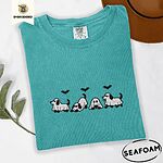 Seafoam Comfort Colors T-shirt embroidered with four puppies in white ghost sheets with black floppy ears and tails under three flying black bats
