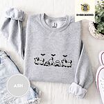Ash crewneck sweatshirt folded with denim shorts, white sneakers and a potted plant, embroidered with four puppies in white ghost sheets with black floppy ears and tails under three flying black bats