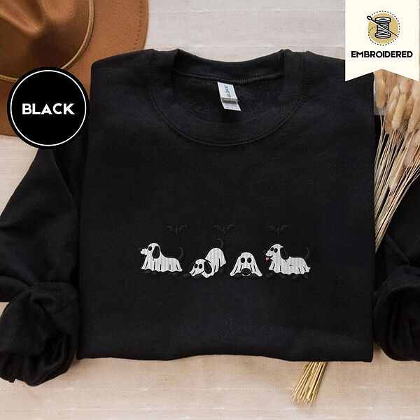 Black crewneck sweatshirt with a brown felt hat and dried bunny tail grass, embroidered with four puppies in white ghost sheets with black floppy ears and tails under three flying black bats