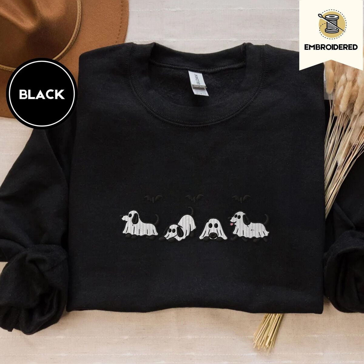 Ghost Puppy Sweatshirt – Black Black crewneck sweatshirt with a brown felt hat and dried bunny tail grass, embroidered with four puppies in white ghost sheets with black floppy ears and tails under three flying black bats