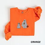 Orange crewneck sweatshirt laid flat on a white background, embroidered with a ghost sipping iced coffee and carrying a jack-o'-lantern pail while walking a little yellow lab in a ghost sheet on a leash