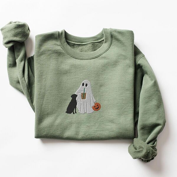 Military Green crewneck sweatshirt laid flat on a white background, embroidered with a ghost lab mom sipping iced coffee and carrying a jack-o'-lantern pail, with a black lab sitting against her