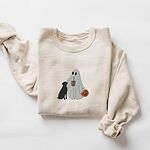 Sand crewneck sweatshirt laid flat on a white background, embroidered with a ghost lab mom sipping iced coffee and carrying a jack-o'-lantern pail, with a black lab sitting against her