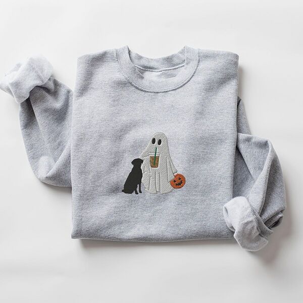 Sport Grey crewneck sweatshirt laid flat on a white background, embroidered with a ghost lab mom sipping iced coffee and carrying a jack-o'-lantern pail, with a black lab sitting against her
