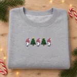 Gnome cat sweatshirt in Sport Grey laid flat with pine sprigs, candy canes and fairy lights
