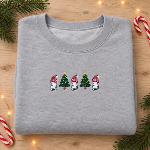 Gnome cat sweatshirt in Sport Grey laid flat with pine sprigs, candy canes and fairy lights