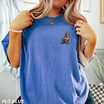 Woman in a Flo Blue T-shirt with a small golden retriever and USA flag embroidered on the left chest
