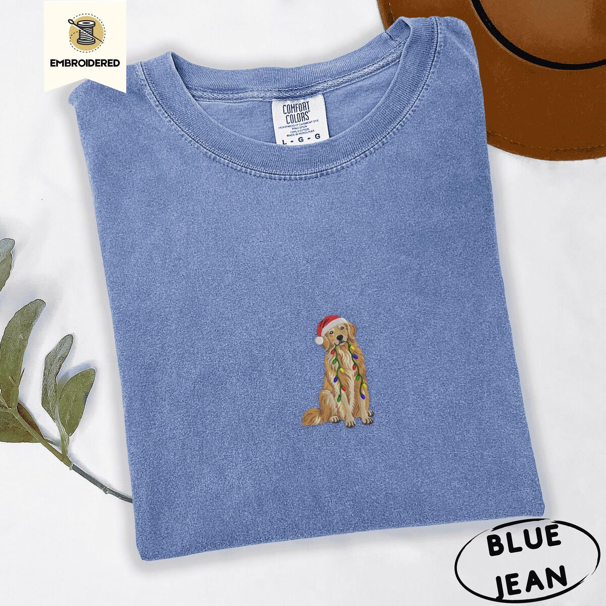 Golden Retriever Christmas Lights Shirt – Blue Jean Blue Jean Comfort Colors T-shirt embroidered with a golden retriever in a red Santa hat holding a strand of colorful Christmas lights