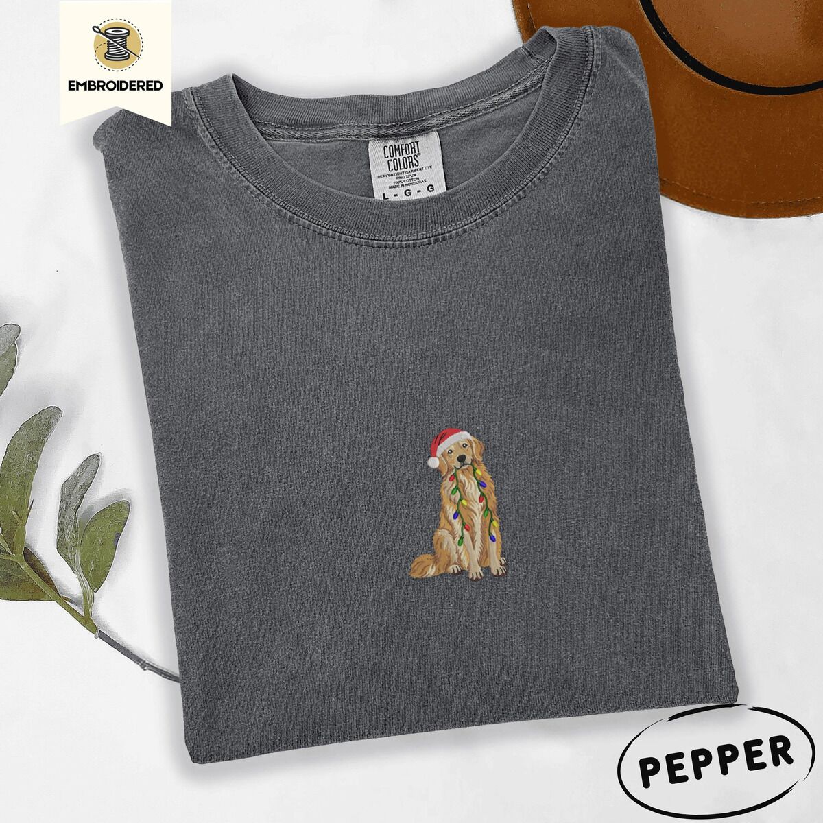 Golden Retriever Christmas Lights Shirt – Pepper Pepper Comfort Colors T-shirt embroidered with a golden retriever in a red Santa hat holding a strand of colorful Christmas lights