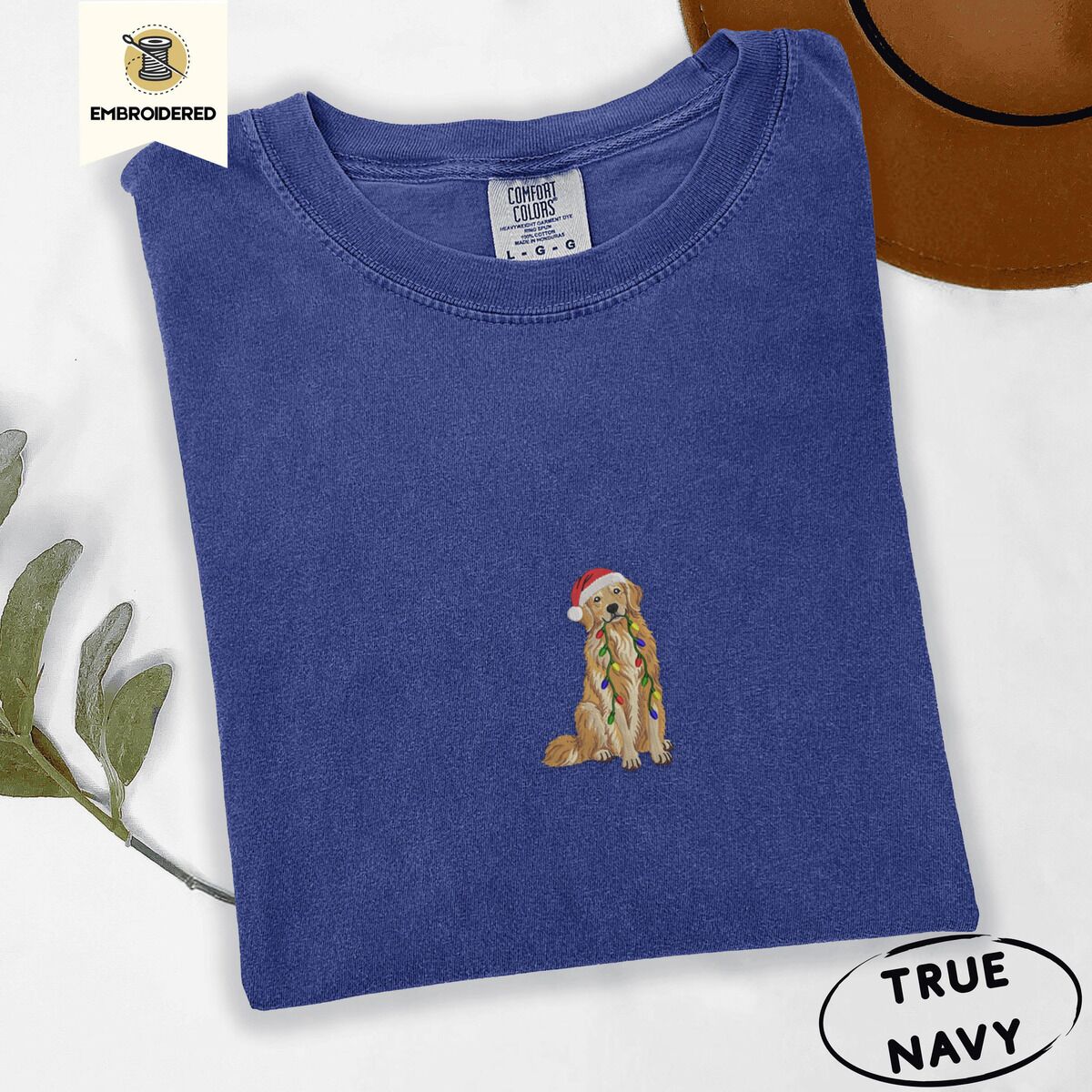 Golden Retriever Christmas Lights Shirt – True Navy True Navy Comfort Colors T-shirt embroidered with a golden retriever in a red Santa hat holding a strand of colorful Christmas lights