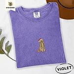 Violet Comfort Colors T-shirt embroidered with a golden retriever in a red Santa hat holding a strand of colorful Christmas lights