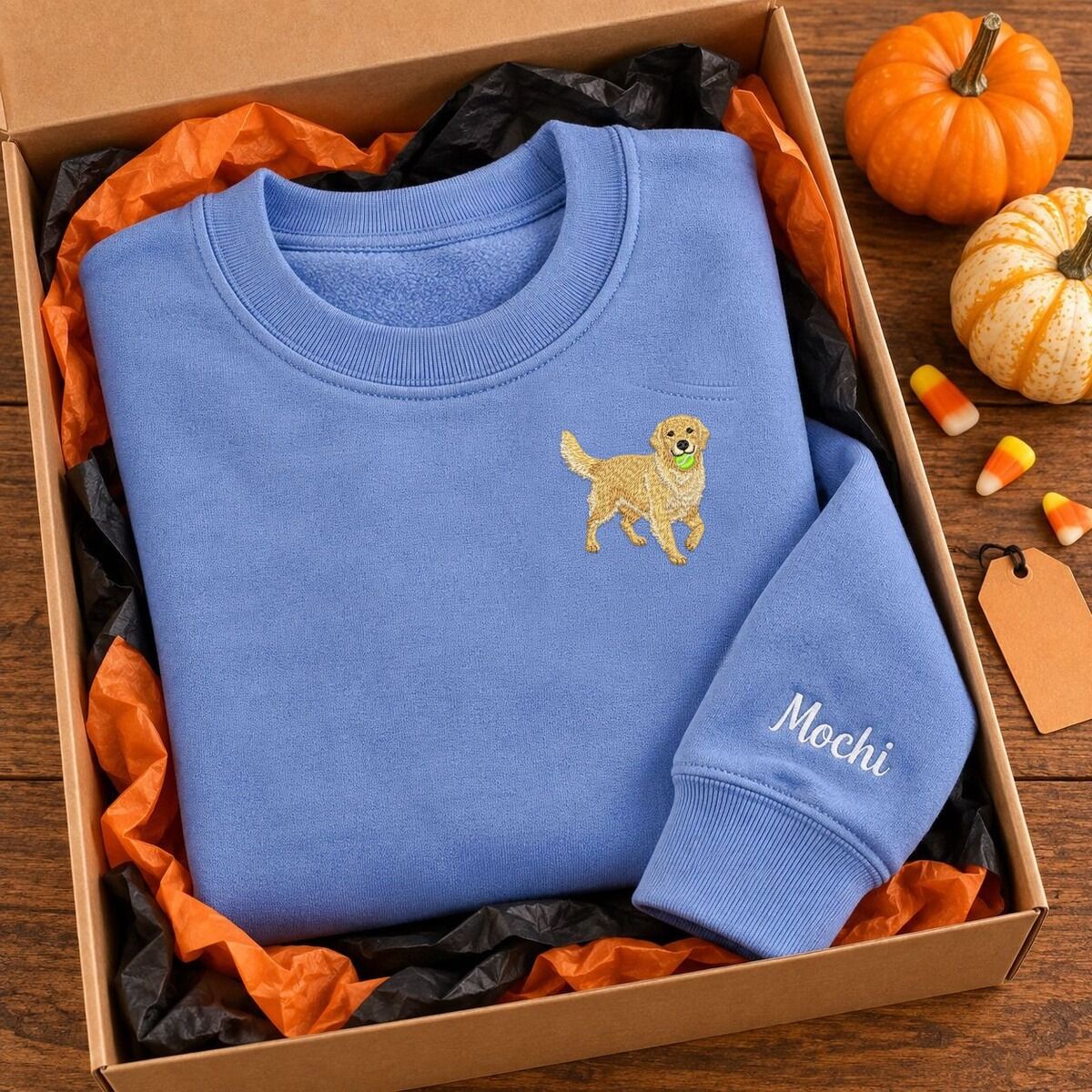 Golden Retriever Crewneck in a Gift Box Blue golden retriever crewneck with the name Mochi on the sleeve in a gift box with orange tissue paper and pumpkins