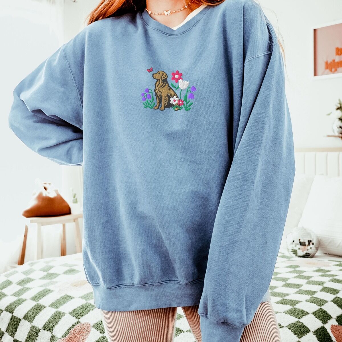 Golden Retriever Flower Sweatshirt - worn in Blue Jean Woman in an oversized Blue Jean crewneck sweatshirt embroidered with a sitting golden retriever among spring flowers
