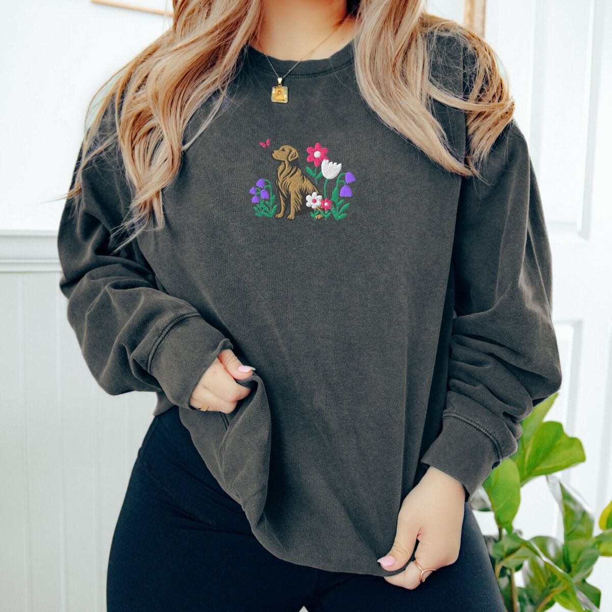 Golden Retriever Flower Sweatshirt – Pepper Woman in a Pepper crewneck sweatshirt embroidered with a sitting golden retriever among spring flowers