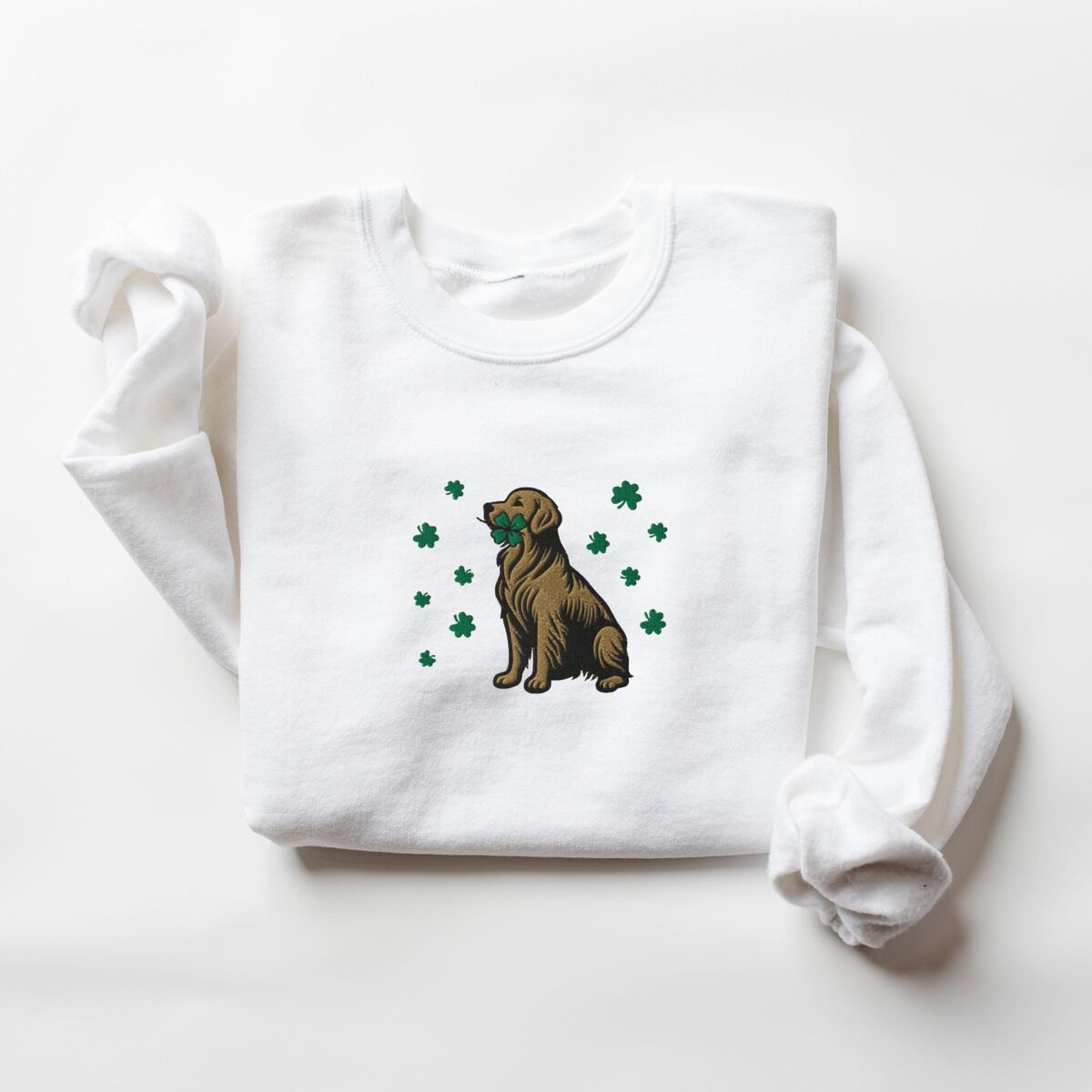 Golden Retriever Four Leaf Clover Sweatshirt - White White crewneck sweatshirt laid flat, embroidered with a sitting golden retriever holding a four leaf clover in its mouth, ringed by green shamrocks