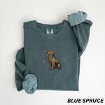 Blue Spruce crewneck sweatshirt laid flat, embroidered with a golden retriever holding a string of Christmas lights in its mouth