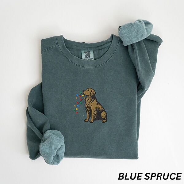 Blue Spruce crewneck sweatshirt laid flat, embroidered with a golden retriever holding a string of Christmas lights in its mouth