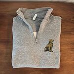 Folded Sport Grey quarter zip pullover on a wooden table, embroidered with a small sitting golden retriever on the left chest