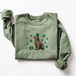 Military Green crewneck sweatshirt laid flat, embroidered with a sitting golden retriever in a green leprechaun hat with a pot of gold and green shamrocks