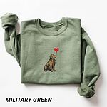 Military Green crewneck sweatshirt laid flat, embroidered with a sitting golden retriever holding the string of a red heart balloon in its mouth