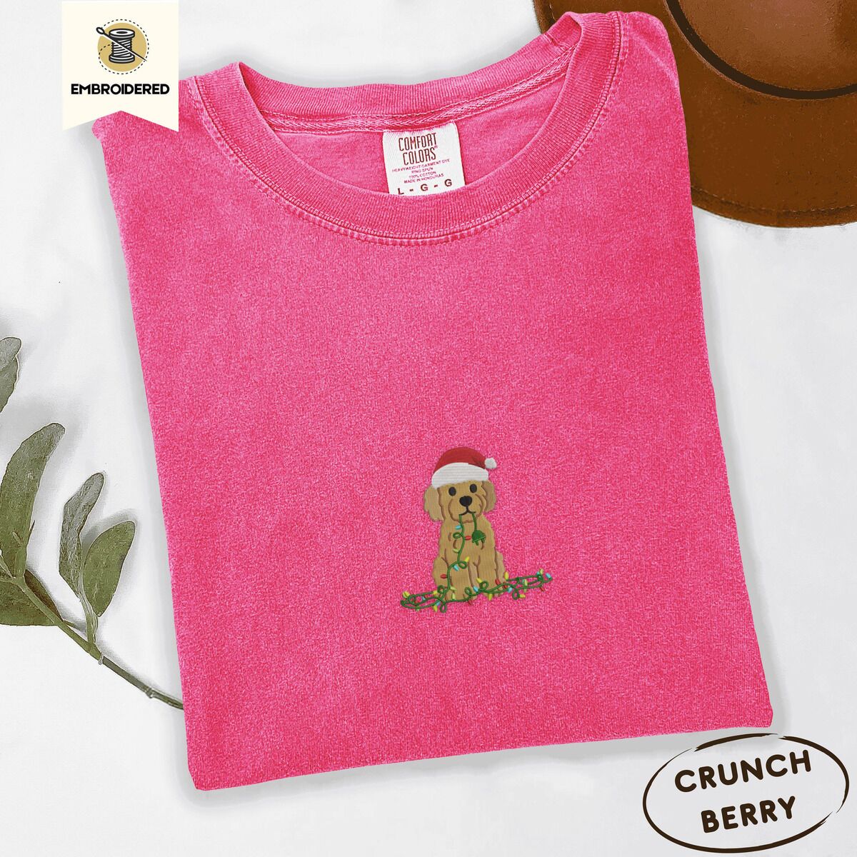 Goldendoodle Christmas Shirt – Crunchberry Crunchberry Comfort Colors T-shirt embroidered with a curly apricot goldendoodle puppy in a Santa hat chewing on a tangled string of Christmas lights