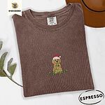 Espresso Comfort Colors T-shirt embroidered with a curly apricot goldendoodle puppy in a Santa hat chewing on a tangled string of Christmas lights
