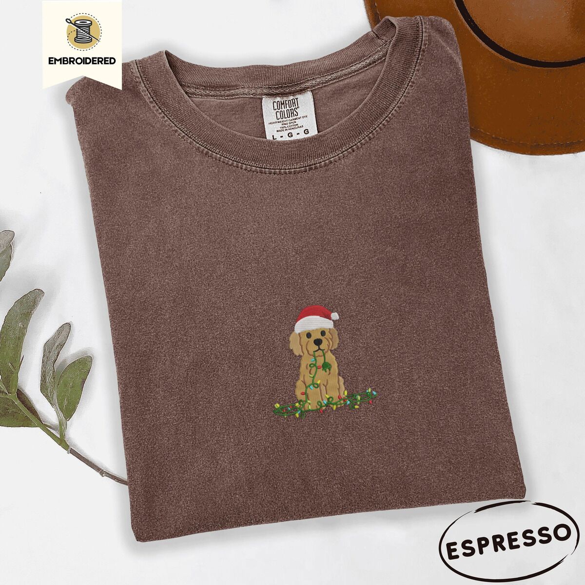 Goldendoodle Christmas Shirt – Espresso Espresso Comfort Colors T-shirt embroidered with a curly apricot goldendoodle puppy in a Santa hat chewing on a tangled string of Christmas lights