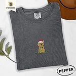 Pepper Comfort Colors T-shirt embroidered with a curly apricot goldendoodle puppy in a Santa hat chewing on a tangled string of Christmas lights