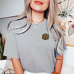 Smiling woman in a Grey T-shirt embroidered with a shaggy golden doodle face on the left chest