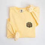 Butter crewneck sweatshirt laid flat with a knotted sleeve, embroidered with a small shaggy golden doodle face on the left chest