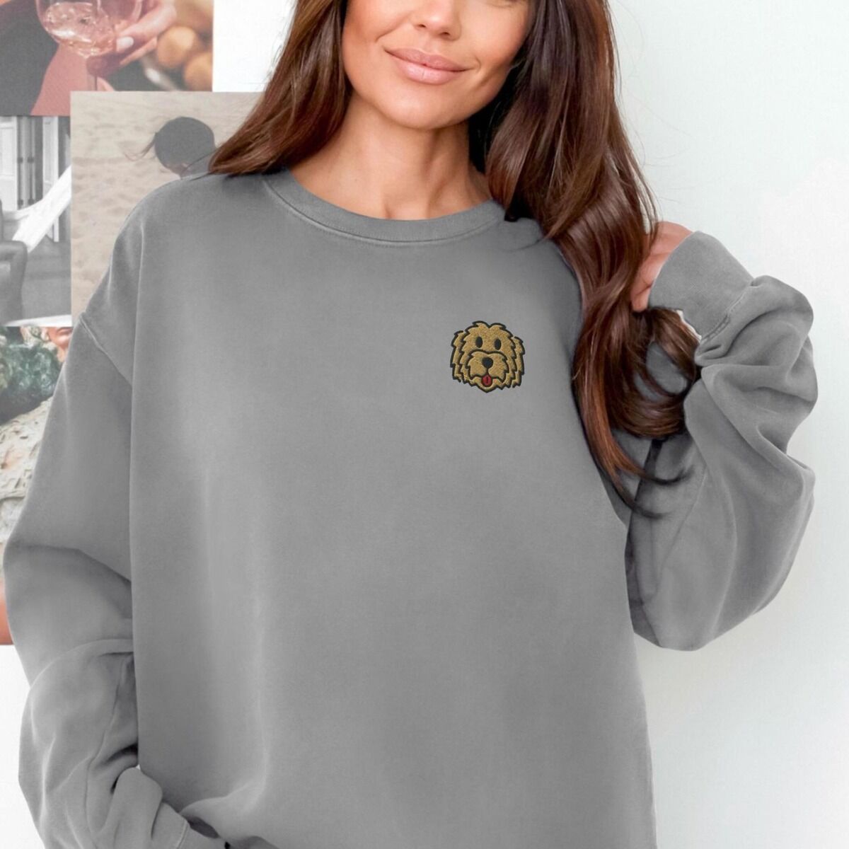Goldendoodle Face Sweatshirt – Grey Smiling woman in a Grey crewneck sweatshirt embroidered with a small golden doodle face on the left chest
